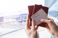 Closeup of beautiful woman hand holding passports and boarding pass tickets at airport terminal. Travel and holiday concept. Termi Royalty Free Stock Photo