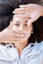 Closeup of a beautiful young mixed race woman with an afro framing her face with her hands. Looking for the perfectly Royalty Free Stock Photo