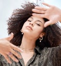 Closeup of a beautiful young mixed race woman with an afro framing her face with her hands. Looking for the perfectly Royalty Free Stock Photo