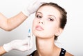 Closeup of Beautiful young woman gets injection in eye and lips area from beautician. preservation of beauty concept Royalty Free Stock Photo