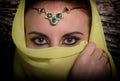 Closeup of beautiful young woman with oriental make-up and shawl over her head. caucasian woman dressed in oriental