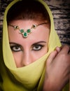 Closeup of beautiful young woman with oriental make-up and shawl over her head. caucasian woman dressed in oriental