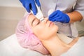 Closeup of beautiful young woman receiving ultrasound facial exfoliation and cavitation facial peeling with ultrasonic Royalty Free Stock Photo