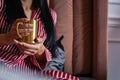 Closeup beauty female hands in pajamas holding golden metallic mug with hot beverage relaxing on bed Royalty Free Stock Photo