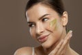 Closeup beauty portrait of cheerful woman with herbal face cream on skin. Facial treatment Royalty Free Stock Photo