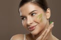 Closeup beauty portrait of cheerful woman with herbal face cream on skin. Facial treatment Royalty Free Stock Photo