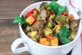 Closeup beef meat stewed with vegetables in ceramic pot on wooden background Royalty Free Stock Photo