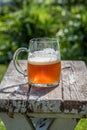 Closeup of a beer mug on old wood table top in sunlight