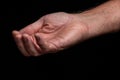 Closeup of a begging hand gesture on a black background