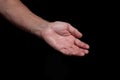 Closeup of a begging hand gesture on a black background