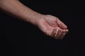 Closeup of a begging hand gesture on a black background