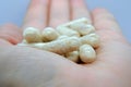 Closeup of a beige pills in one hand. Medicine pills