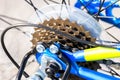 Closeup of bicycle gears, chain and cables, neon yellow and blue