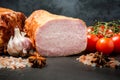 closeup big pieces of smoked ham with spices, garlic, and tomatoes Royalty Free Stock Photo