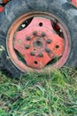 Closeup of big red russian tractor wheel on autumn grass during seasonal harvest crops in Bulgaria rural detail with sharp focus Royalty Free Stock Photo