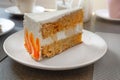 Closeup of big slice of carrot cake on a white plate in a cafe Royalty Free Stock Photo