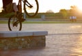 Closeup, bike and man outdoor, trick and sun flare with training, fun and wellness. Male person, cyclist or biker