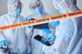 Closeup of biohazard tape blocking of prohibited area. Team of scientists cleaning prohibited area. Medical csi team Royalty Free Stock Photo