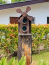 Closeup of bird wood house with gable roof and windmill in the g Royalty Free Stock Photo