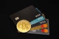 Closeup of a bitcoin and credit cards isolated on a black background Royalty Free Stock Photo