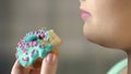 Closeup of bitten donut, chubby woman eating unhealthy food, diabetes, obesity