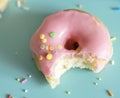 Closeup of bitten donut on light blue background