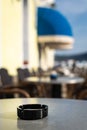 Closeup of a black ash tray on the table of a coffee shop Royalty Free Stock Photo