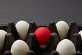 Closeup of black cardboard box with white and red raw eggs on black background with copy space. Easter concept Royalty Free Stock Photo
