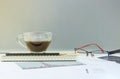 Closeup black coffee in transparent cup of coffee on note book and pencil with work paper on blurred wooden desk and glass wall te Royalty Free Stock Photo