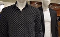 Closeup of a black diamond-printed shirt and a blazer with a white t-shirt on mannequins at a store