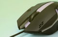 Closeup of a black gaming optical mouse on a blue background