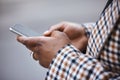 Closeup, black hands and smartphone for typing, outdoor and connection for social media, chatting and online reading