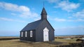 Closeup of a black Hellnar Church under the blue sky in Iceland