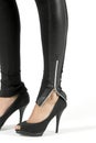 Closeup of black high heels with tight pants with zipper at the ankles Royalty Free Stock Photo