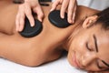 Closeup of black lady having healing hot stone massage Royalty Free Stock Photo