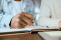 Closeup, black man hand and writing in notebook at desk for studying, planning and support for goals. Student men, book Royalty Free Stock Photo