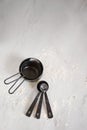 Closeup of black measuring spoons on a table covered in flour. Royalty Free Stock Photo