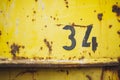 Closeup of a black number written on an old yellow rusty wall - a cool background and wallpaper Royalty Free Stock Photo