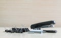 Closeup black stapler and black stamp paper clip , office equipment on blurred wood desk and wall in office room textured backgrou Royalty Free Stock Photo