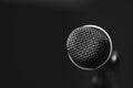 Closeup black vocal microphone mounted on mic stand, blurry red dark bcakground Royalty Free Stock Photo