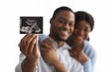 Baby sonogram in happy black couple hands