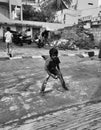Closeup of black and white different age group kids playing Buguri or Spinning Tops on Roadside during holiday