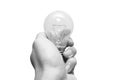 Closeup black and white man hand holding old tungsten light bulb isolated on white background Royalty Free Stock Photo