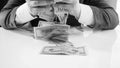 Closeup black and white image of greedy businessman grabbing and throwing big stack of money Royalty Free Stock Photo