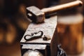 Closeup of a blacksmith anvil with a hammer, firesteel and flint.