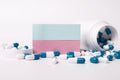 Closeup of a blank blue and pink sticky note and blue-white pills spilling out of pill bottle. Medical concept. Blank space for Royalty Free Stock Photo