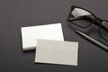 Closeup of blank business cards, metalic pen, male dark glasses on the grey surface Royalty Free Stock Photo