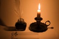Closeup of a blank music sheet with a vintage ink pot and a lit candle Royalty Free Stock Photo