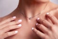 Closeup blonde model with bright make-up, bare shoulders and short hair with shaved temples in modern round silver jewelry