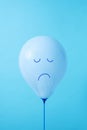 Blue balloon with a sad face Royalty Free Stock Photo